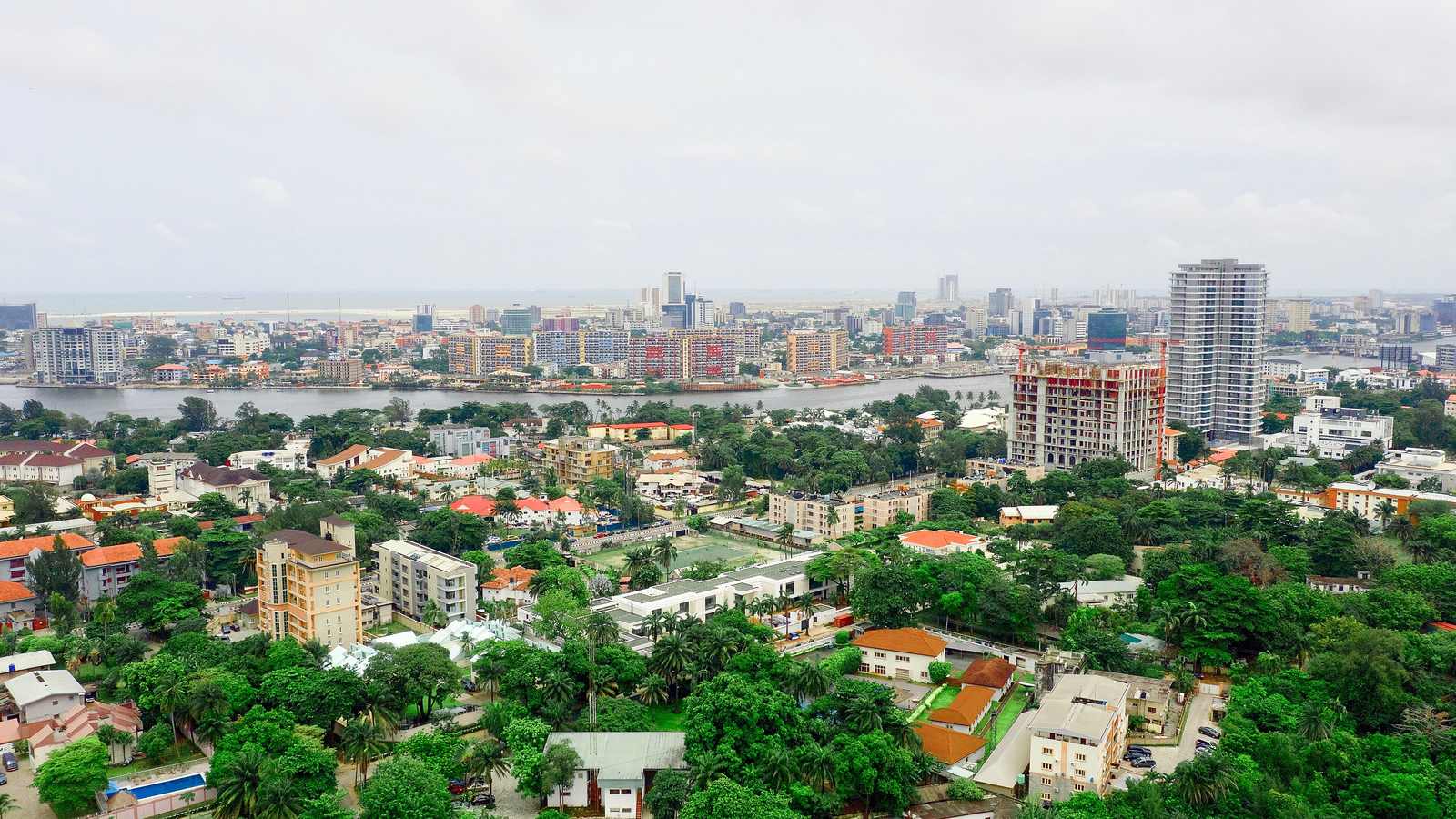 Aerial view of a leafy Lagos neighbourhood with estate housing and distant towers