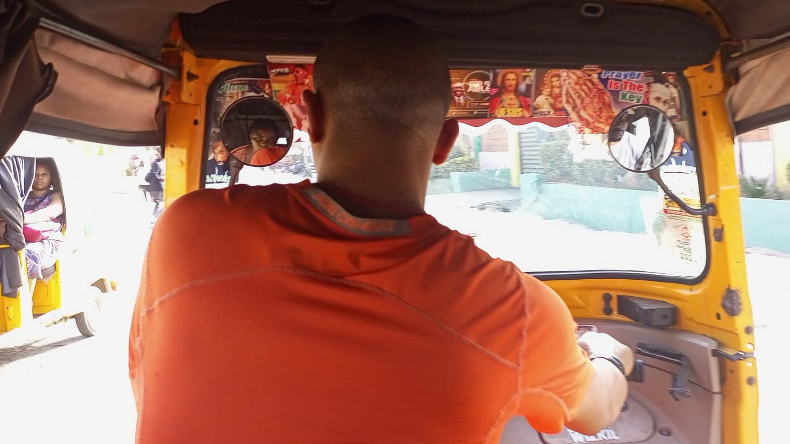 View from inside a Lagos keke tricycle as the rider watches the street ahead